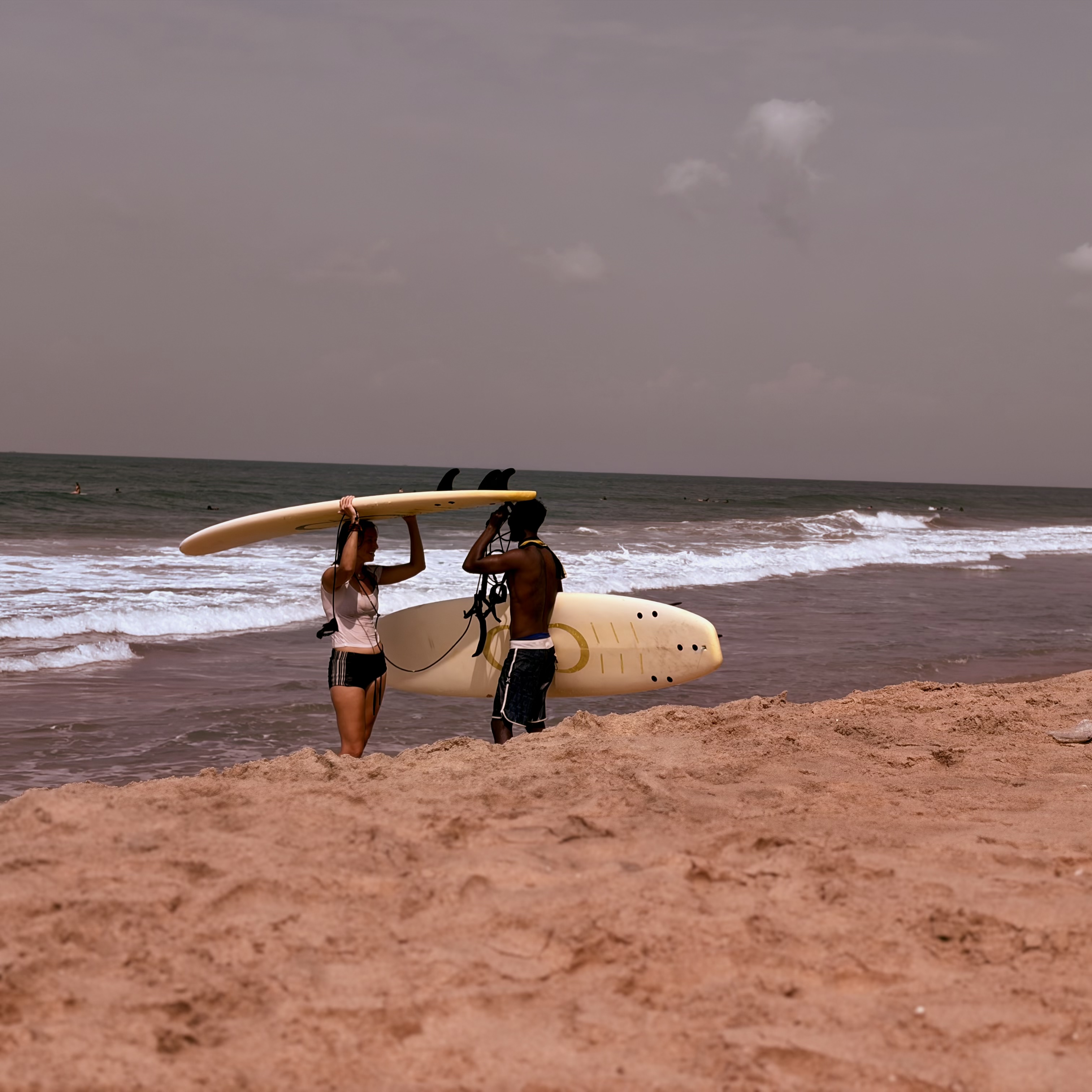 Two surfers holding boards near the sea in Varkala